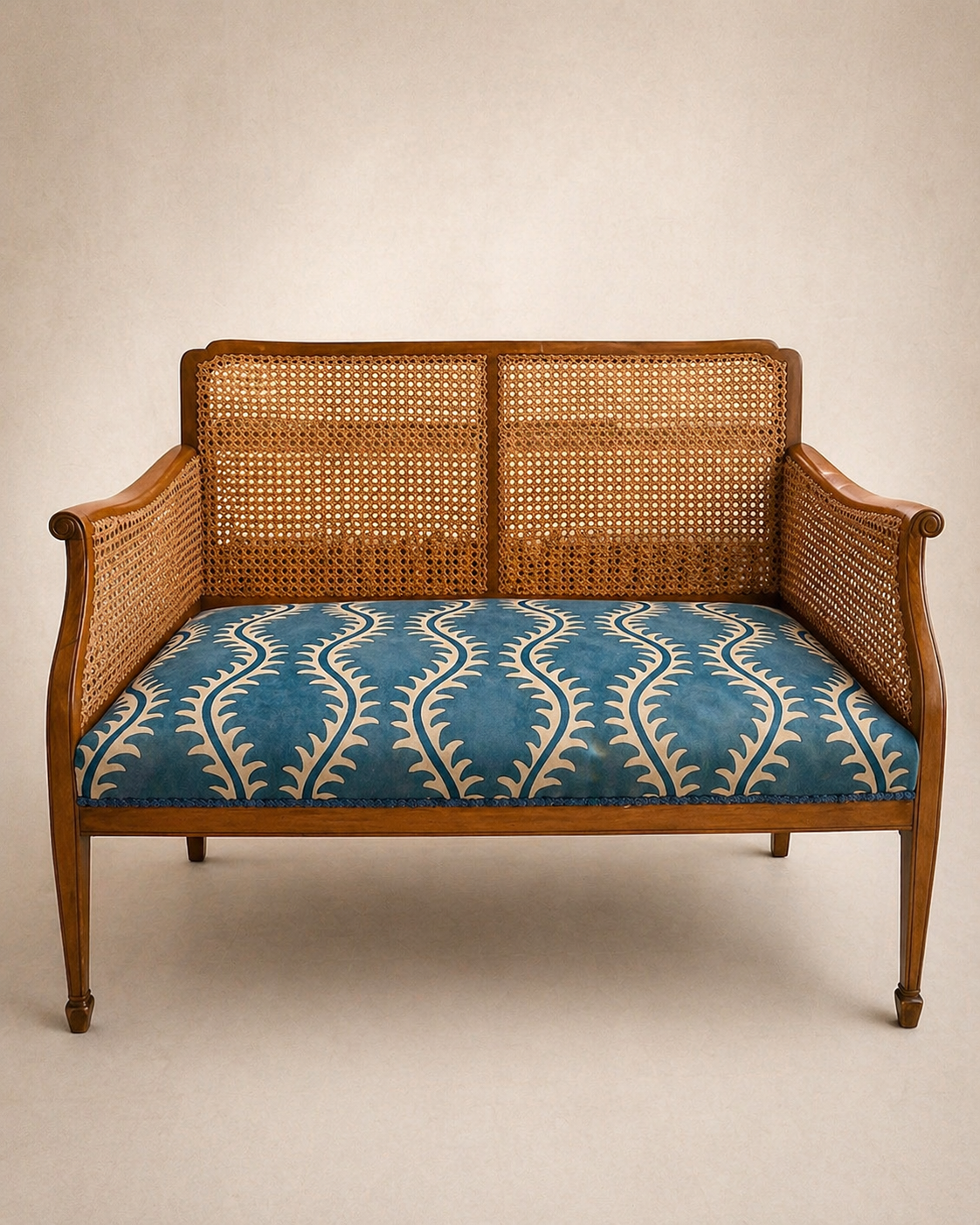Cane-back settee with blue patterned seat cushion